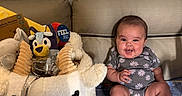 Kinsley is registered to the contest to win money with this photo: animal_shaped_basket, baby, blanket, celebration, child, couch, cute, easter_basket, face, happy, home, indoor, onesie, person, plush, sitting, smiling, social_media_post, toy, window_blinds