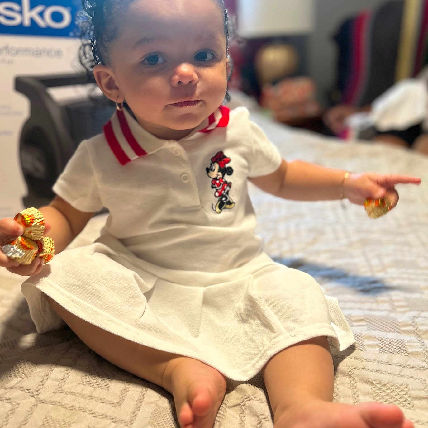 Zayanna is registered to the contest to win money with this photo: baby, bed, child, cozy, curly_hair, cute, earrings, face, foot, hand, indoors, minnie_mouse, person, portrait, room, sitting, toddler, toy, treats, white_dress