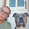 woman, person, dog, pet, selfie, portrait, glasses, brown_hair, short_hair, face, looking_at_camera, outdoor, door, house, entrance, collar, black_and_white, gray_dog, sitting, companion