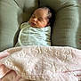 baby, newborn, swaddled, blanket, cushion, sleeping, infant, soft_texture, pink, white, face, head, resting, cozy, indoors, person, peaceful, wrapped, young_child, child
