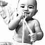 baby, infant, diaper, pearls, child, smiling, cute, happy, sitting, hand, face, portrait, black_and_white, skin, eyes, chewing, cute_expression, soft_focus, close_up, childhood