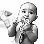 baby, infant, child, toy, chewing, black_and_white, portrait, curious, expression, close_up, hands, diaper, cute, young, candid, indoor, face, head, skin, playful
