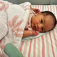 Leilia is registered to the contest to win money with this photo: baby, newborn, blanket, striped_sheet, infant, face, hand, pink, white, cozy, sleeping_area, soft_texture, cute, portrait, lying_down, child, resting, indoors, warm, wrapped