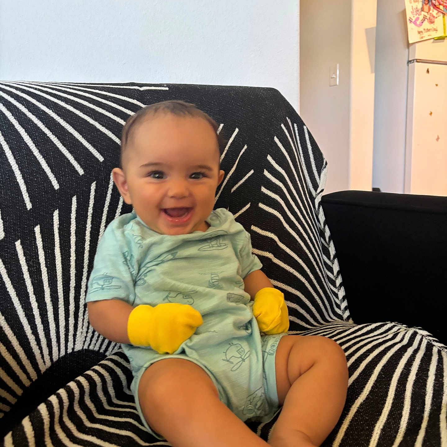 Leilia joined the competition — help win amazing prizes! baby, black_and_white, bright, chair, child, comfort, cute, furniture, happy, home, indoor, infant, mittens, onesie, pattern, person, portrait, sitting, smiling, young