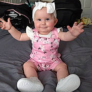 Serenity is registered to the contest to win money with this photo: baby, child, infant, smiling, pink_clothing, headband, white_shoes, arms_outstretched, sitting, bed, indoor, cute, happy, person, face, room, car_seat, blanket, footwear, domestic