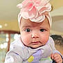 baby, infant, face, headband, flower, clothing, purple, pink, person, child, cute, closeup, portrait, indoor, soft_light, curious, holding, shoulder, young, adorable