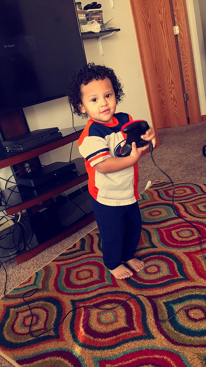 Elijah is registered to the contest to win money with this photo: arm, baby, child, electronic_device, floor, flooring, leg, person, photography, play, room, shoulder, standing, t_shirt, toddler