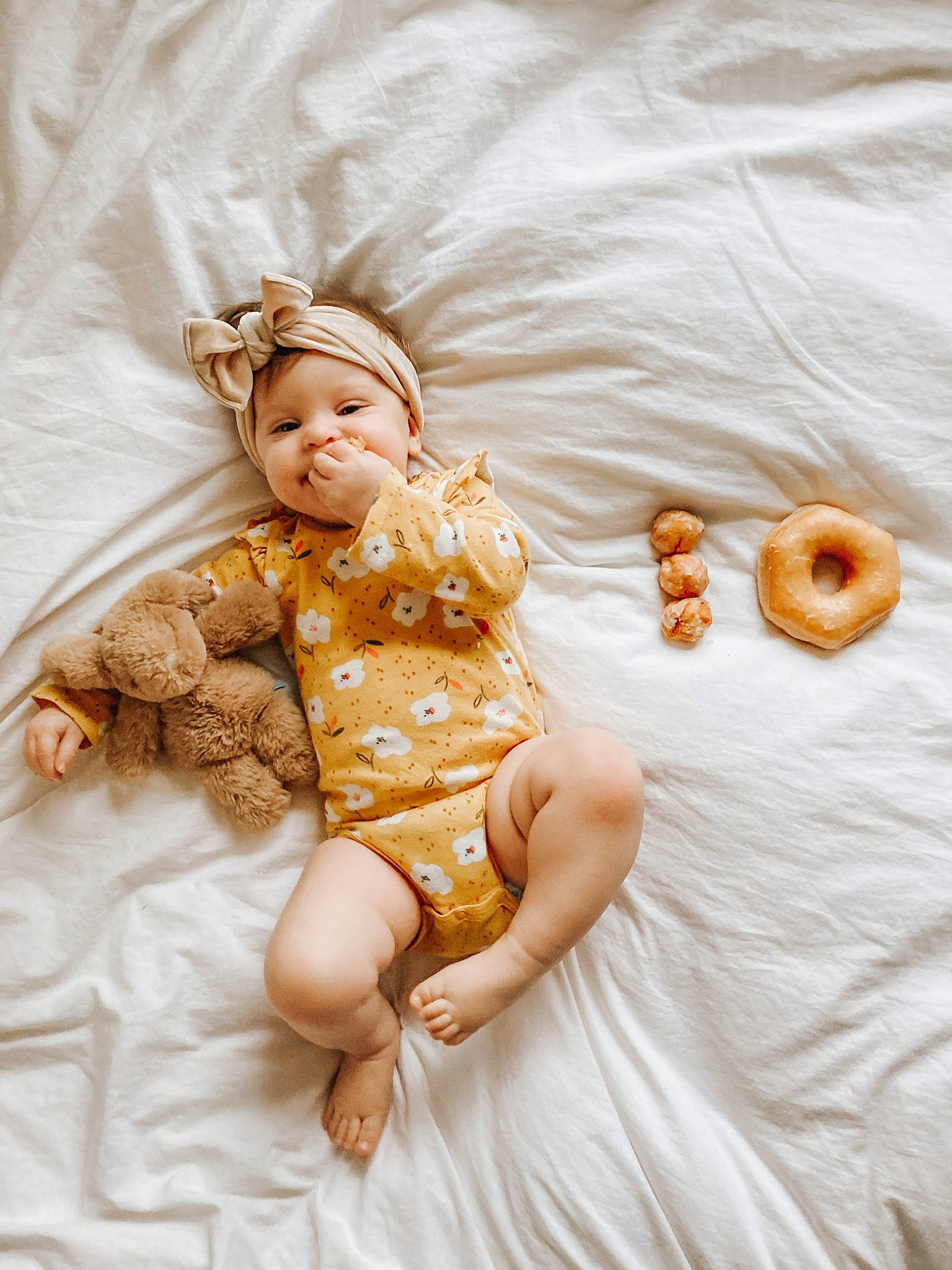 Sunshine is registered to the contest to win money with this photo: baby, baby_toddler_clothing, bagel, baked_goods, comfort, dessert, doughnut, embellishment, finger_food, linens, nose, person, snack