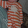 baby, newborn, sleeping, infant, child, portrait, striped_onesie, orange_clothing, white_clothing, ghost_pattern, hearts, couch, blanket, pillow, indoor, cozy, peaceful, face, text_overlay, snapchat_style