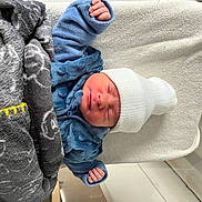 Raphaël participe au concours pour gagner de l'argent avec cette photo : newborn, baby, sleeping, blanket, hat, blue_clothing, hospital, bassinet, towel, infant, cozy, cute, child, person, resting, indoors, soft_texture, wrapped, peaceful, small_hands