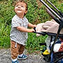 toddler, child, stroller, grass, sidewalk, hand, curious, outdoor, shoes, pants, striped_shirt, nature, walking, baby, person, greenery, footwear, small_child, park, daytime