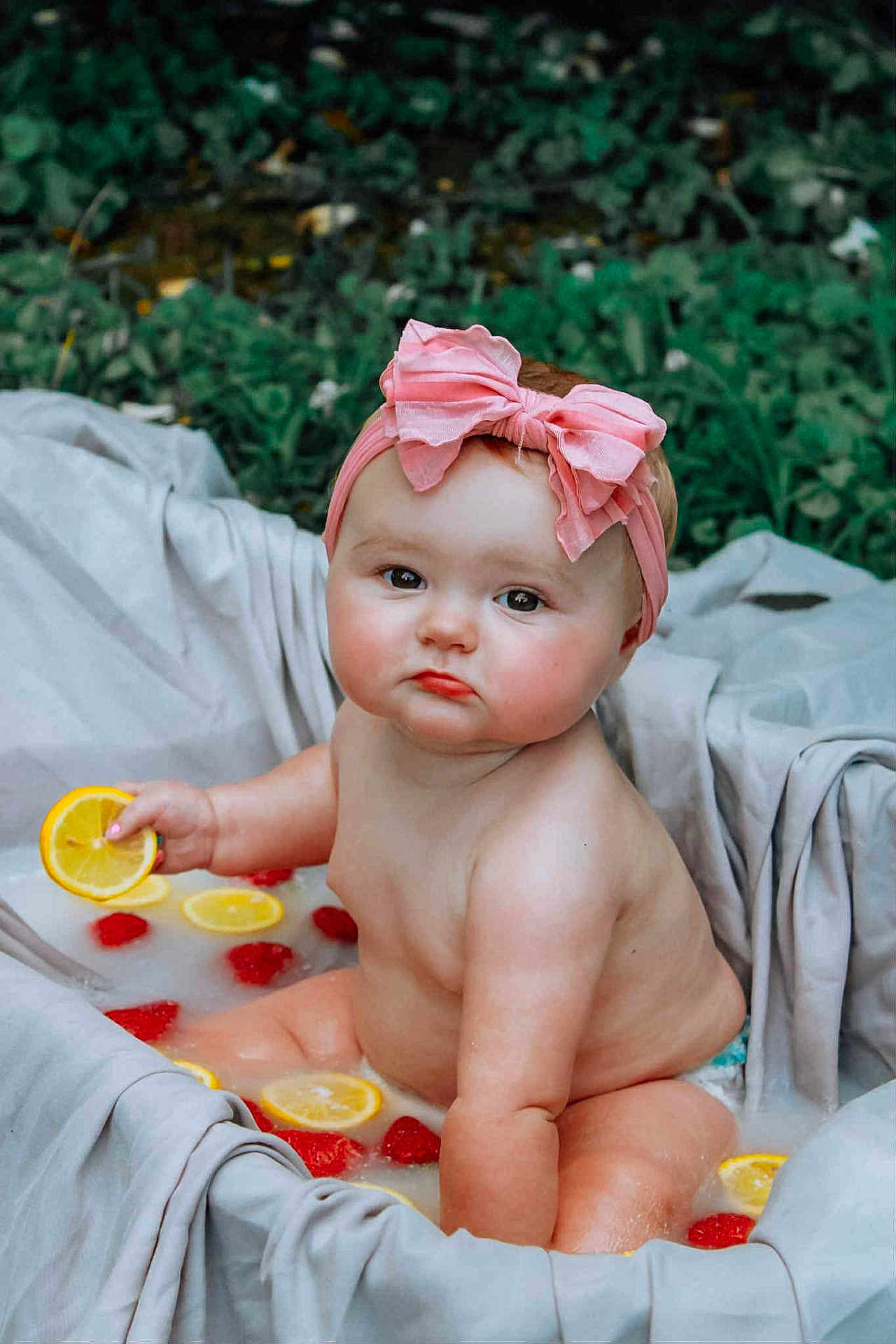 Alattica joined the competition — help win amazing prizes! baby, child, pink_bow, headband, bath, water, lemon_slices, raspberries, fruit, skin, chubby, serious_expression, outdoor, greenery, blanket, fabric, sitting, cute, infant, summer