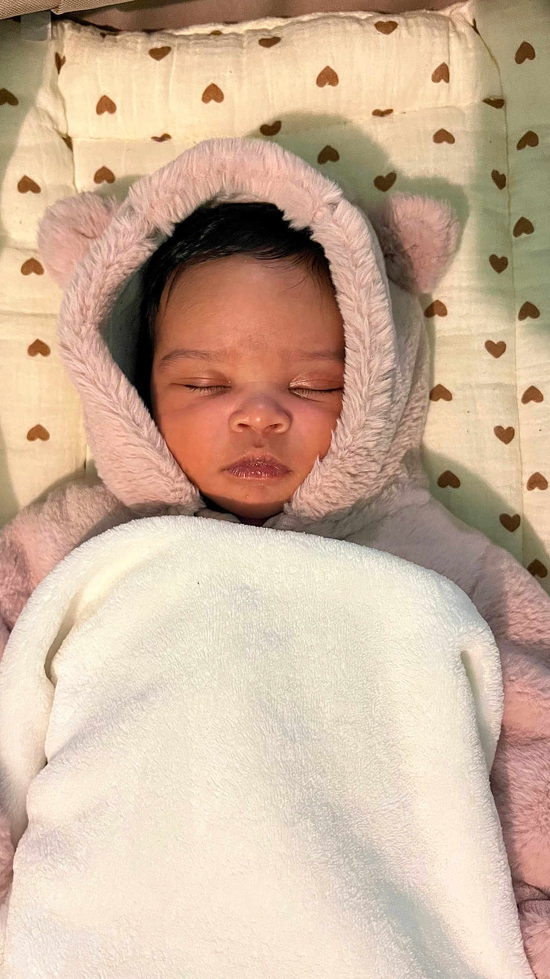 Aïana a rejoint le concours — aidez-le/la à gagner de superbes lots ! baby, sleeping, blanket, hoodie, soft_texture, heart_pattern, cushion, face, closed_eyes, infant, cute, cozy, warm_clothing, resting, indoors, toddler, fur, child, peaceful, portrait