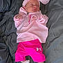 baby, newborn, sleeping, pink_clothing, headband, bow, socks, blanket, infant, child, cute, resting, soft_fabric, casual_wear, under_armour, indoor, portrait, small_hands, peaceful, cozy