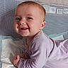 baby, infant, smile, happy, tummy, onesie, purple_clothing, face, child, cute, indoors, resting, young_child, skin, head, hands, blue_eyes, short_hair, fabric, background
