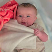 Aliyah joined the competition — help win amazing prizes! baby, blanket, bedding, infant, cute, smile, face, hand, clothing, lying_down, soft_texture, comfort, indoor, child, newborn, portrait, bed, cozy, pink, expression