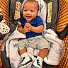 baby, infant, car_seat, shopping_cart, blanket, smile, happy, footwear, socks, clothing, person, indoor, child, cute, baby_shoes, seat, plush, face, hands, portrait