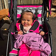Anaiah joined the competition — help win amazing prizes! baby, child, stroller, blanket, pink_clothing, smiling, outdoor, sunlight, happy, person, infant, seat, cute, portrait, face, young_child, casual, daytime, baby_clothes, comfort