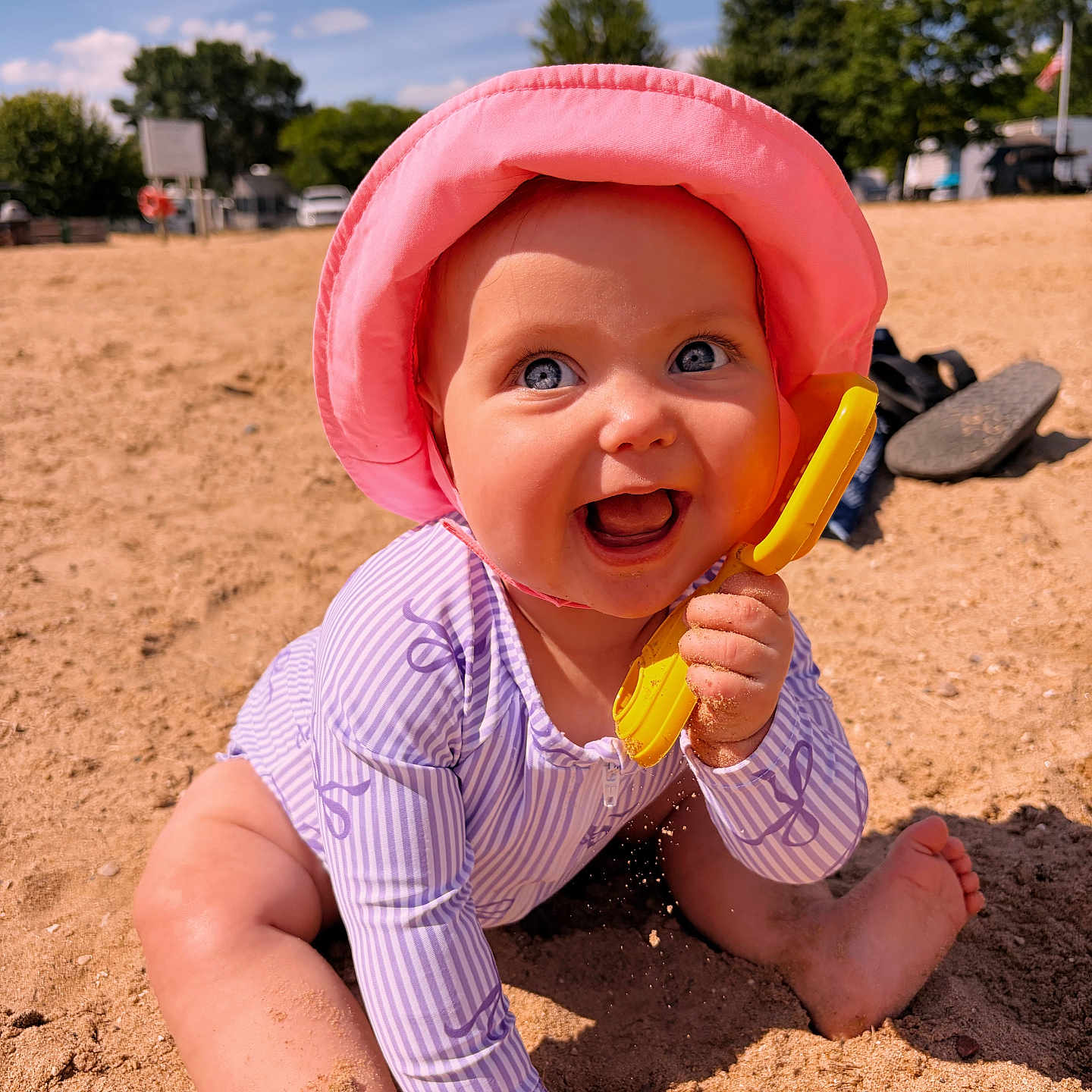 Jensen is registered to the contest to win money with this photo: baby, child, sand, beach, sunhat, toy, yellow_shovel, smile, happy, purple_swimsuit, outdoor, summer, play, sunny, barefoot, cute, portrait, blue_sky, trees, vacation