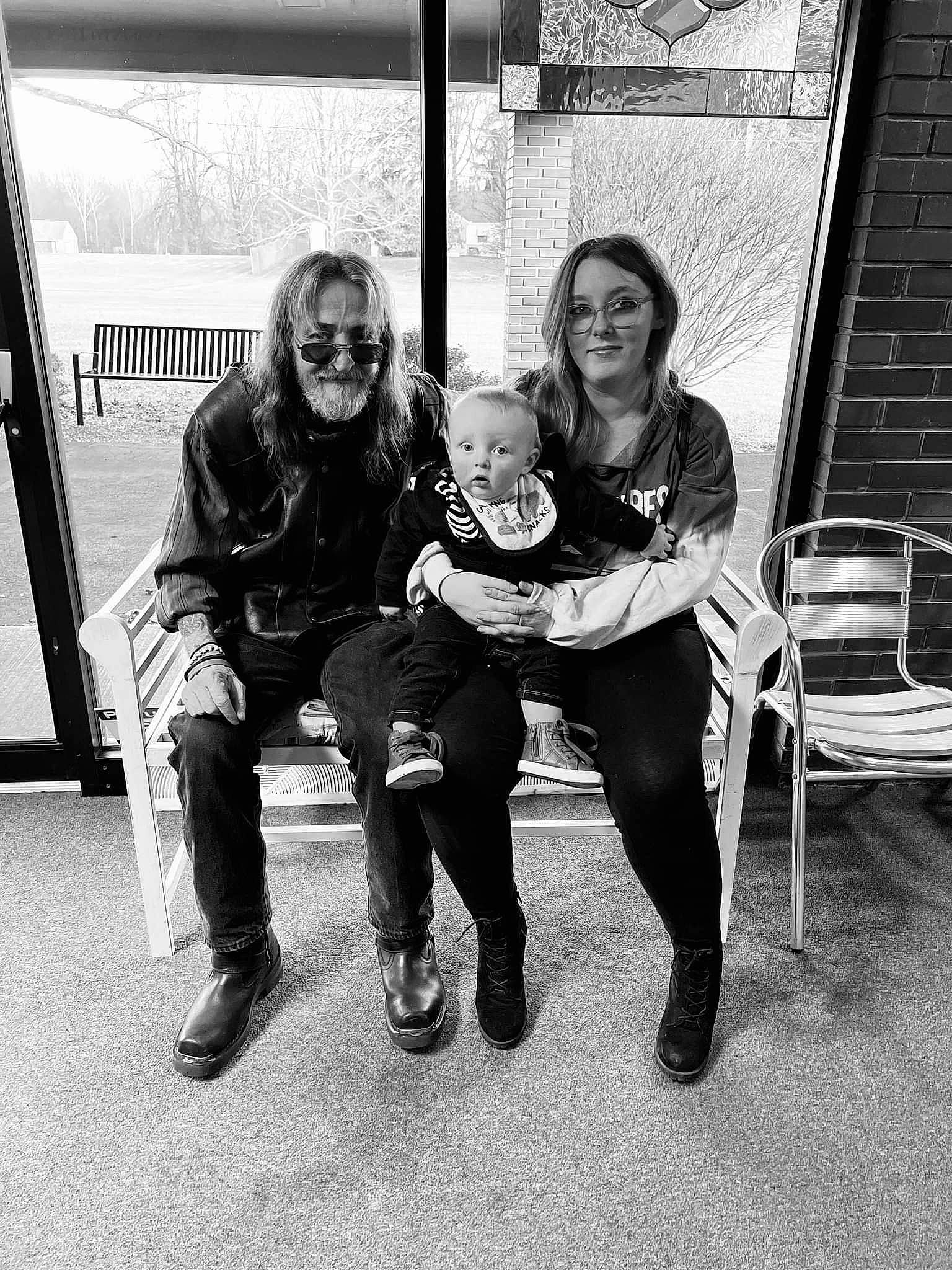 Clint Jr is registered to the contest to win money with this photo: black, black_and_white, boot, chair, child, comfort, eyewear, fun, happy, jacket, joy, lap, monochrome, monochrome_photography, person, sitting, smile, standing, stock_photography, street