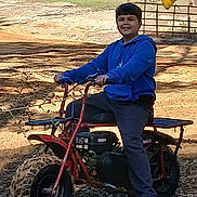 Julian joined the competition — help win amazing prizes! child, boy, smile, minibike, dirt_bike, outdoor, forest, trees, dirt, flag, blue_hoodie, casual_clothing, tire, vehicle, portrait, sunlight, sand, woodland, youth, recreation