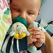 Noah is registered to the contest to win money with this photo: baby, infant, pacifier, plush_toy, stuffed_animal, hands, close_up, striped_clothing, cheeks, sleepy, cuddle, caregiver_arm, nursery, toy_penguin, crib, soft_toy, portrait, indoor, skin, comfort