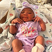 Sahara joined the competition — help win amazing prizes! newborn, baby, infant, purple_onesie, bow_hat, socks, hospital_blanket, colorful_footprints, hand, resting, cute, sleepy, portrait, indoors, soft_lighting, skin, clothing, hospital, care, comfort