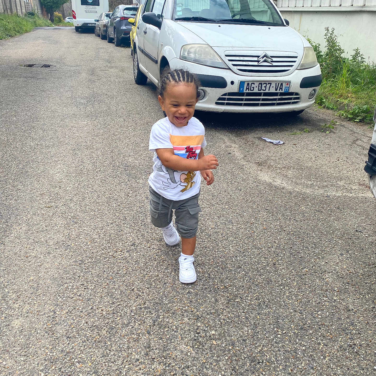 Kervens participe au concours pour gagner de l'argent avec cette photo : asphalt, braided_hair, cars, child, clothing, daylight, greenery, happy, outdoor, person, playful, running, sidewalk, smiling, street, toddler, tom_and_jerry, tshirt, urban, white_shoes