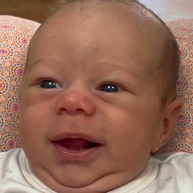 Janël a rejoint le concours — aidez-le/la à gagner de superbes lots ! baby, cheeks, child, close_up, cushion, expression, eyes, face, hair, happy, head, indoors, infant, mouth, onesie, patterned, portrait, resting, skin, smiling