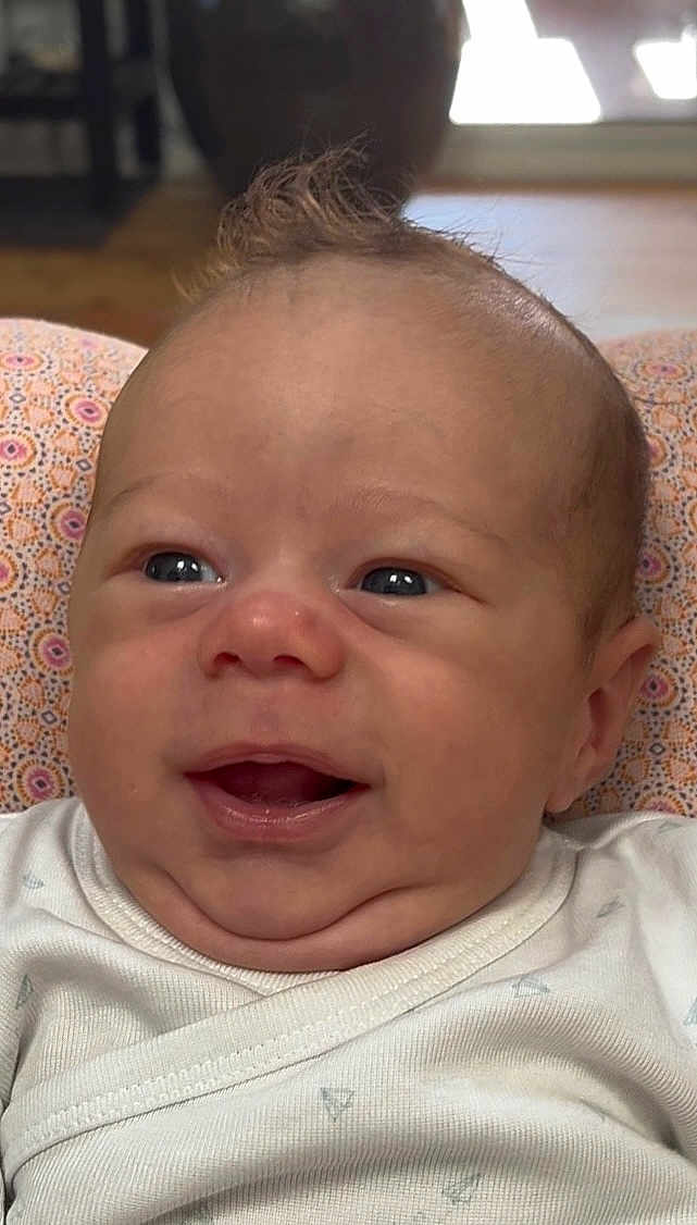 Janël a rejoint le concours — aidez-le/la à gagner de superbes lots ! baby, smiling, close_up, infant, face, eyes, hair, onesie, patterned, cushion, indoors, happy, skin, mouth, cheeks, head, expression, resting, child, portrait