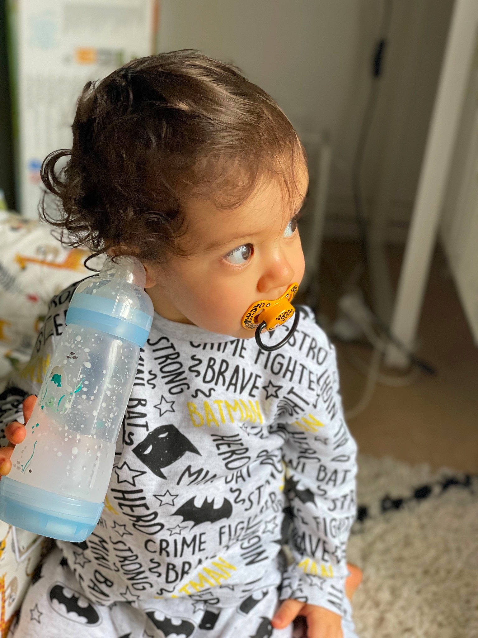 Hayden participe au concours pour gagner de l'argent avec cette photo : baby, baby_toddler_clothing, blond, bottle, cheek, child, doll, drinkware, fashion_design, flooring, pattern, person, plastic, plastic_bottle, room, sitting, skin, sleeve, toddler, toy