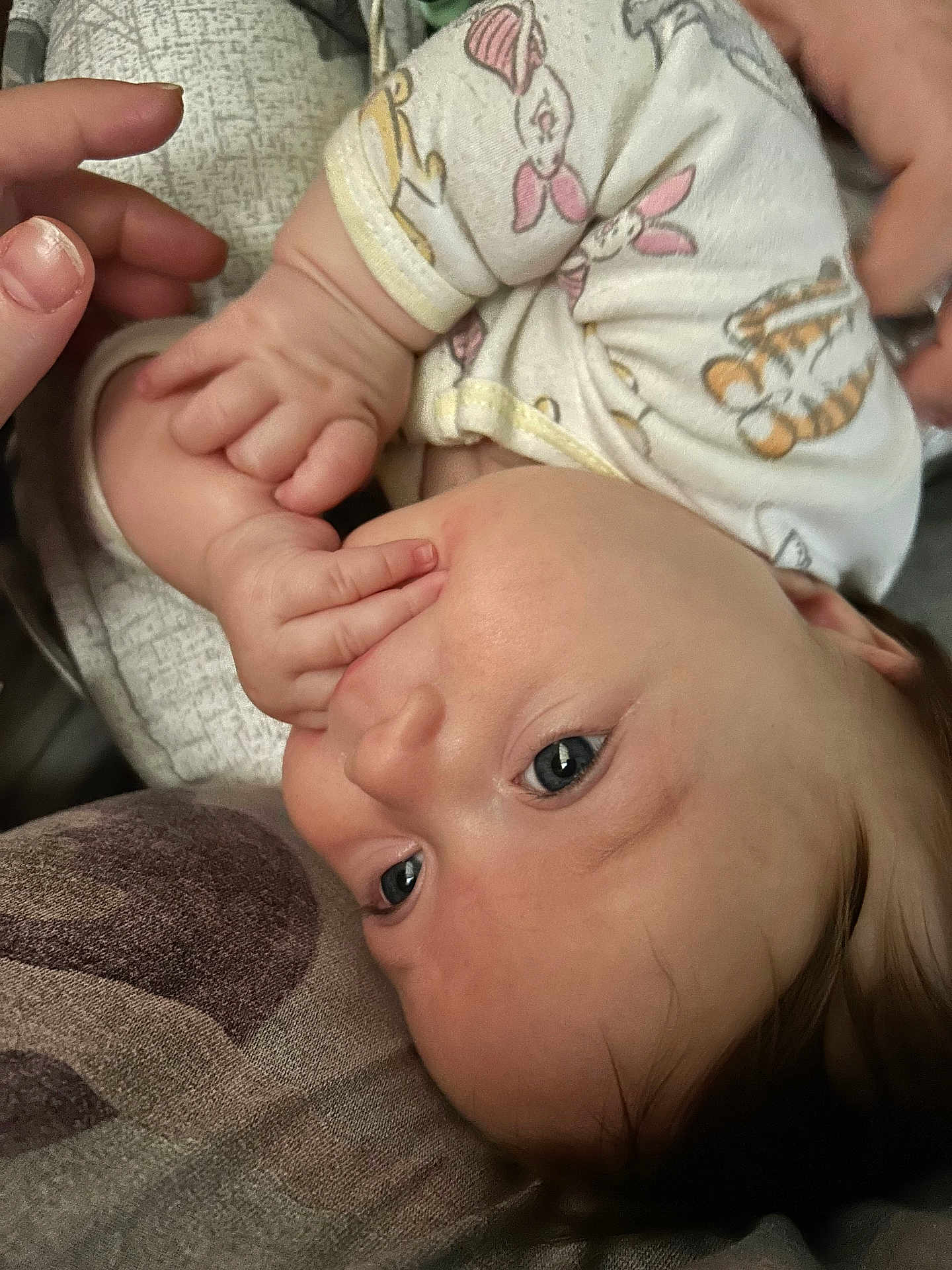 Evelyn joined the competition — help win amazing prizes! baby, infant, face, hand, fingers, onesie, animal_print, pillow, resting, curious, skin, blue_eyes, closeup, cute, child, person, sleepwear, soft, comfort, indoor