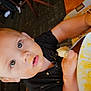 baby, black_shirt, child, curious_eyes, eating, face, food, fork, hand, high_chair, indoor, meal, messy_face, person, plate, restaurant, seat, table, toddler, wooden_chair