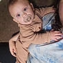 adult, baby, beige, blanket, blue, brown, casual, child, clothing, comfort, couch, holding, home, indoor, pacifier, person, portrait, relaxing, soft, tie_dye