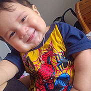 Liam joined the competition — help win amazing prizes! baby, child, smiling, indoor, tshirt, spiderman, necklace, furniture, chair, water_bottle, person, face, happy, cute, closeup, hand, sitting, skin, hair, room