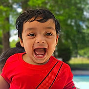 Agastya is registered to the contest to win money with this photo: child, toddler, smiling, happy, red_shirt, face, mouth_open, outdoor, daylight, nature, greenery, hair, portrait, person, emotion, joy, expression, young, cute, playful
