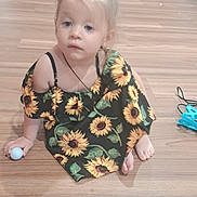 Kaiya joined the competition — help win amazing prizes! toddler, child, girl, sunflower_dress, indoor, wooden_floor, ball, sitting, blonde_hair, curly_hair, footwear, necklace, toy, chair, box, plastic_container, household_items, curious, casual, portrait