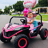 Alailah joined the competition — help win amazing prizes! toddler, birthday, toy_car, pink, balloons, dress, crown, smile, outdoor, street, suburban, child, celebration, happy, vehicle, one_year_old, daytime, grass, house, road