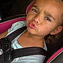 Eliza is registered to the contest to win money with this photo: child, car_seat, seatbelt, face, expression, girl, young, portrait, clothing, sitting, car_interior, seat, hair, earring, pink, blue_shirt, closeup, funny_face, person, safety