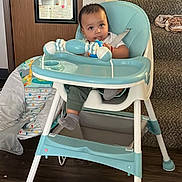 Brayden Smith is registered to the contest to win money with this photo: baby, child, infant, high_chair, toy, colorful_toy, sitting, indoors, home, staircase, door, mirror, blanket, floor, furniture, gray_pants, socks, curious, portrait, photography