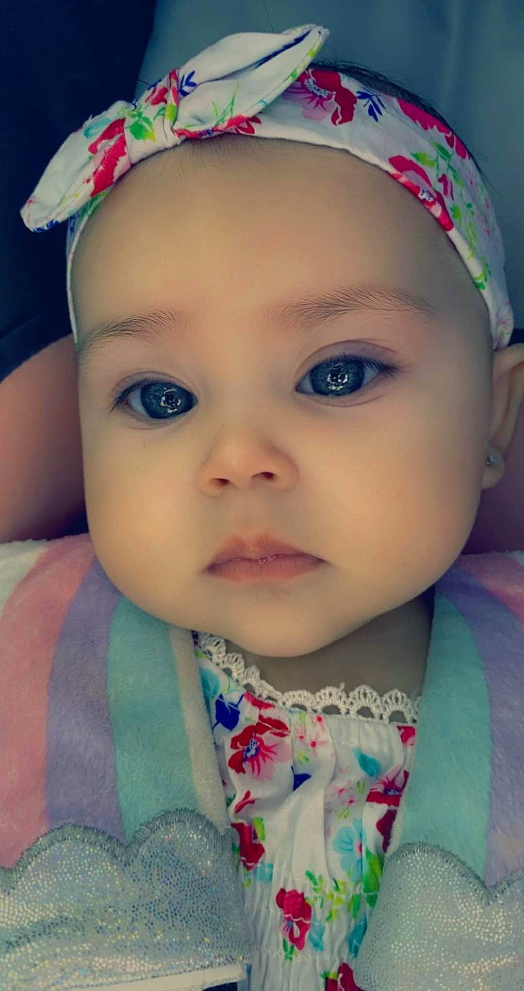 Penelope is registered to the contest to win money with this photo: baby, baby_toddler_clothing, cap, cheek, chin, dress, eye, eyebrow, eyelash, face, green, happy, headwear, human_body, iris, lip, nose, organ, person, product