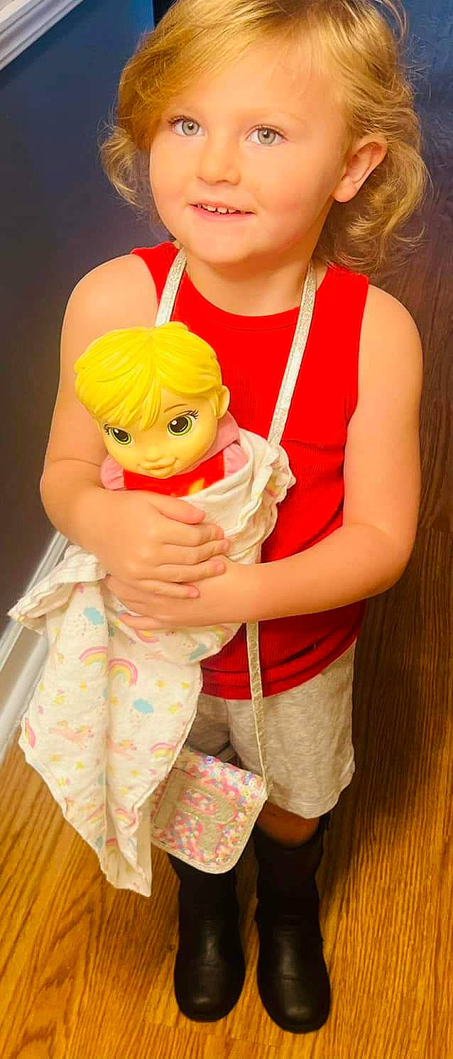 Remi is registered to the contest to win money with this photo: baby, baby_toddler_clothing, child, dress, eyewear, finger, fun, gesture, happy, hat, head, interaction, joy, mouth, orange, person, pink, skin, smile, sunglasses