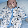 baby, infant, pacifier, onesie, blue, white, animal_print, pillow, sleepwear, clothing, cute, child, newborn, soft, comfort, portrait, indoors, resting, face, human