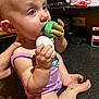 baby, blue_eyes, child, closeup, curious, eggs, expression, face, feet, hands, holding, indoor, infant, kitchen_counter, messy, paint, person, purple_clothing, sitting, skin