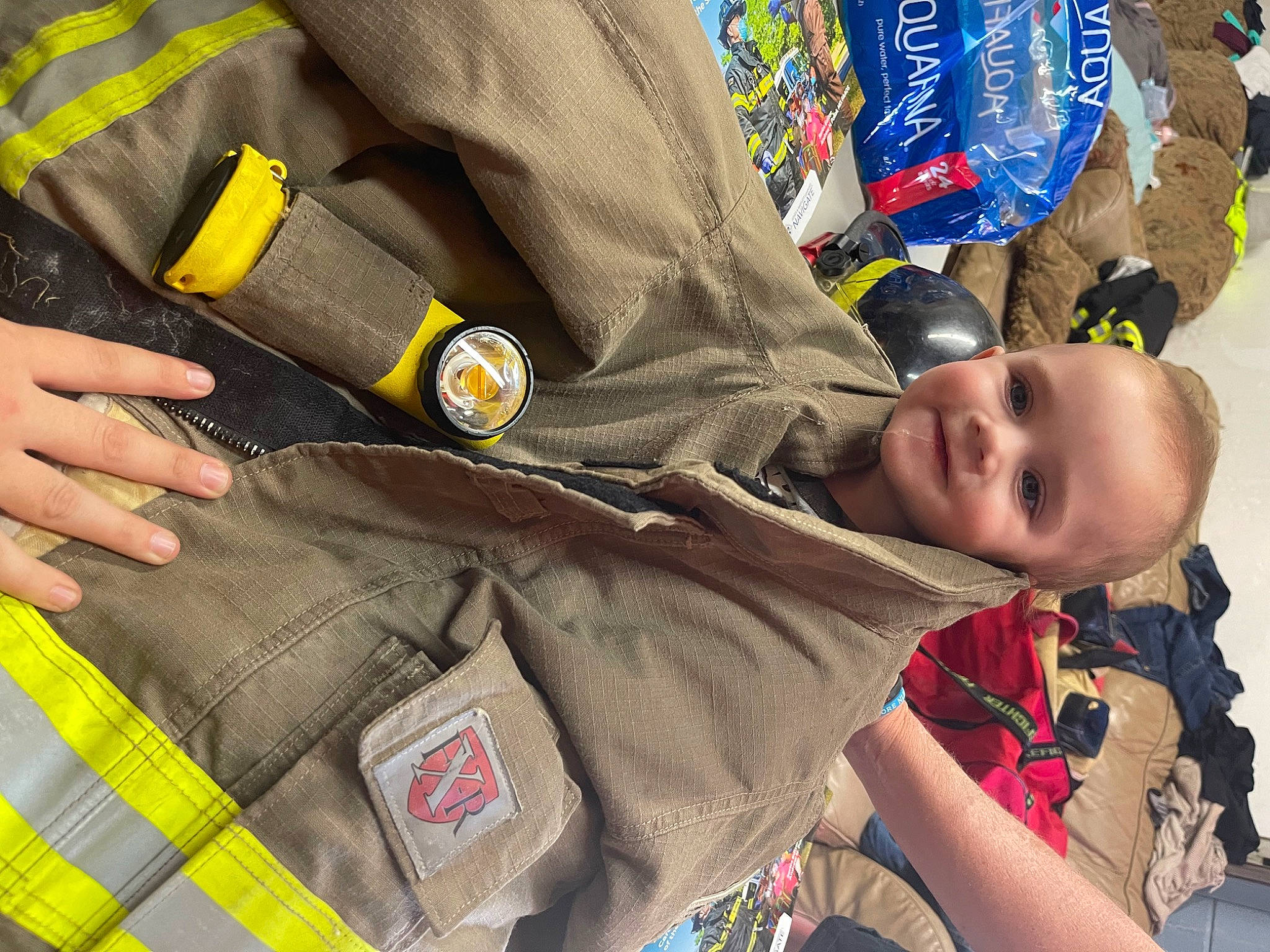 Jordan is registered to the contest to win money with this photo: baby, child, comfort, gesture, hand, happy, joy, law_enforcement, military_person, military_uniform, official, pattern, person, personal_protective_equipment, pocket, security, sleeve, smile, tie, toddler