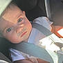 baby, child, car_seat, seatbelt, white_shirt, infant, face, eyes, arm, light, shadow, safety, vehicle, child_safety, cute, portrait, indoors, person, closeup, expression