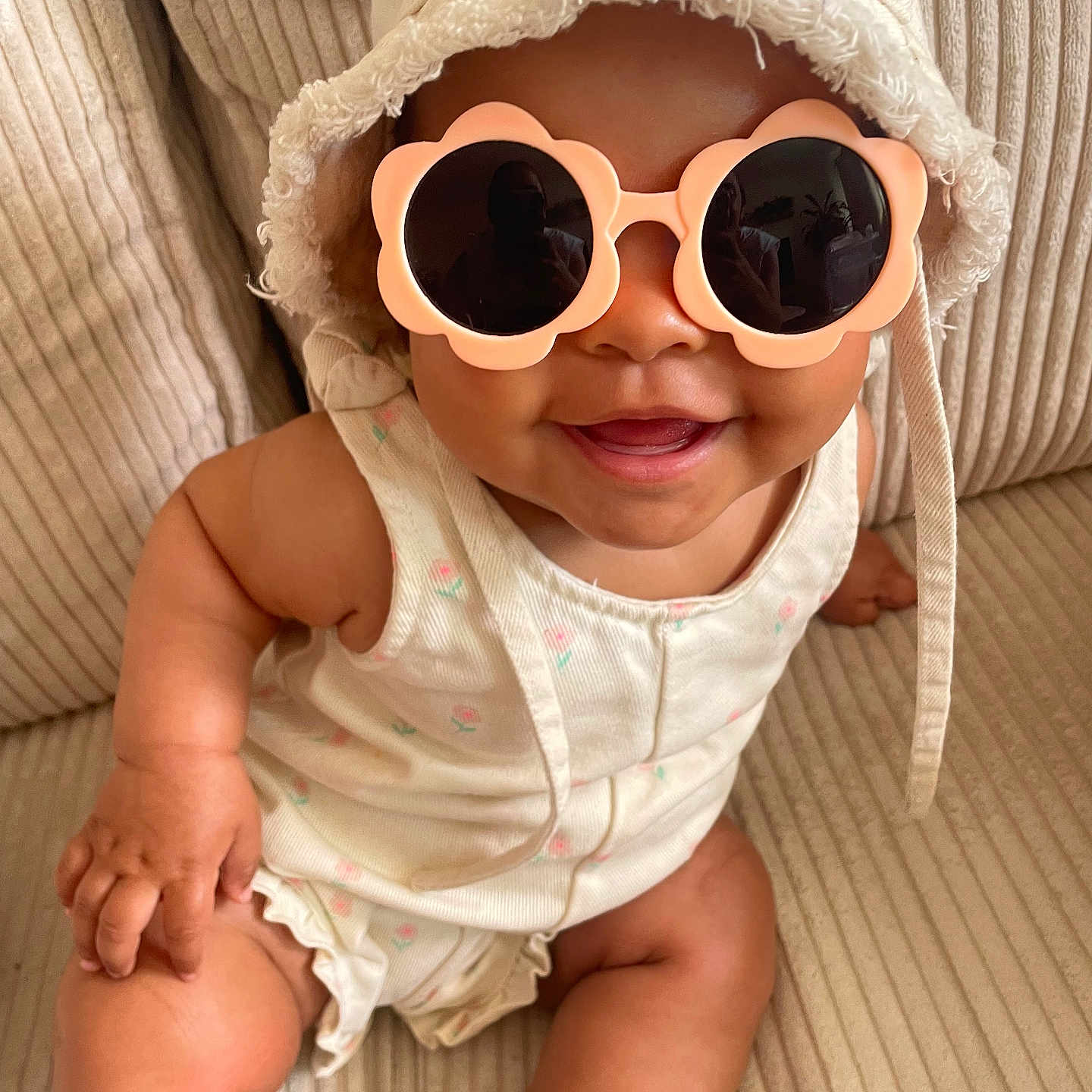 Shany participe au concours pour gagner de l'argent avec cette photo : apparel, baby, bucket_hat, child, clothing, couch, cute, face, furniture, hand, happy, hat, indoor, infant, leg, portrait, sitting, skin, smile, sunglasses