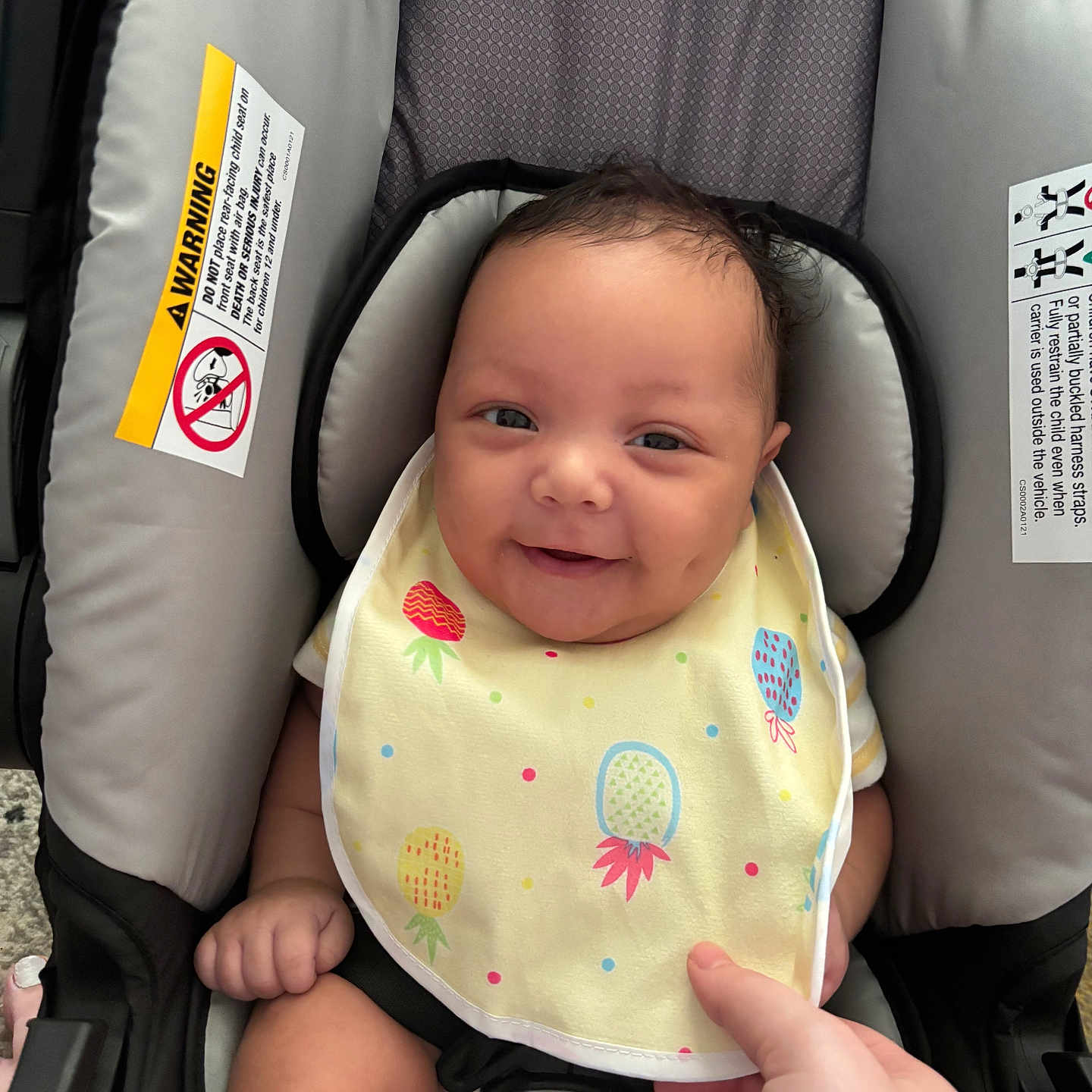 Mazahreon is registered to the contest to win money with this photo: baby, bib, car_seat, child, closeup, clothing, colorful, cute, face, hand, happy, head, indoor, infant, person, safety_harness, seat_belt, sitting, skin, smile