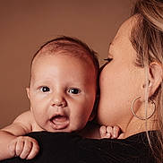 Nahel participe au concours pour gagner de l'argent avec cette photo : baby, woman, child, face, portrait, closeup, skin, hand, earring, hair, expression, person, love, affection, holding, background, studio, warm_colors, adult, intimate