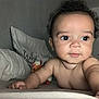 baby, child, infant, bed, pillow, arm, hand, face, skin, eyes, curly_hair, expression, indoor, room, blanket, door, reaching, closeup, person, lying_down